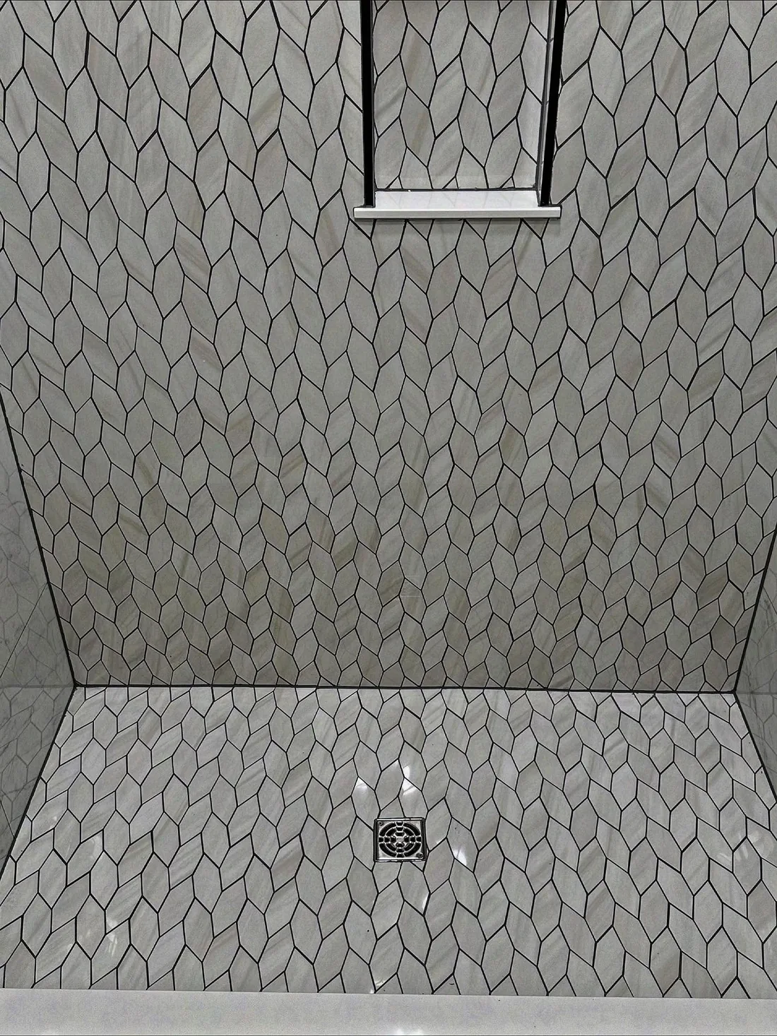Shower with unique grey geometric tile pattern