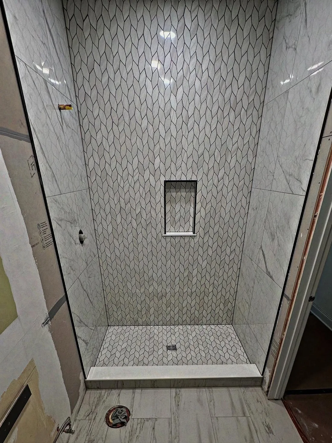 Modern shower with patterned tile wall and floor