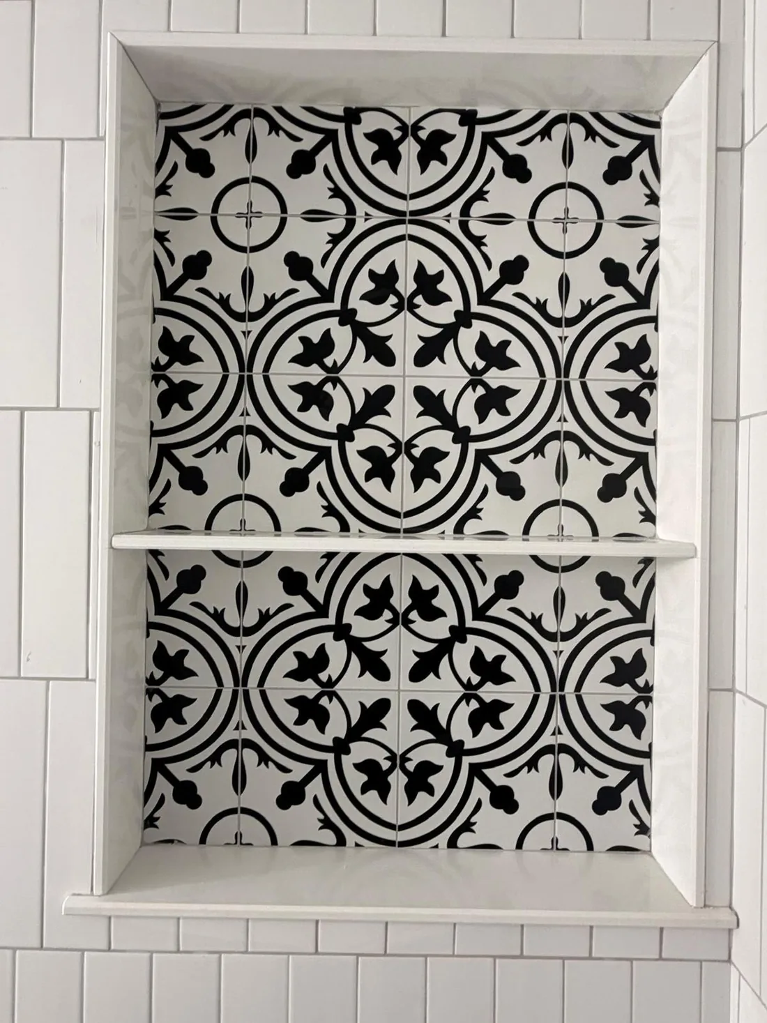 Black and white patterned tile shower niche