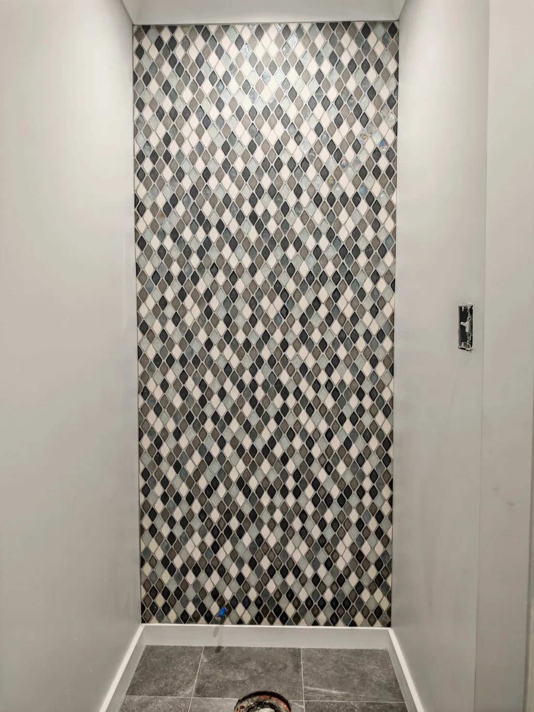 Decorative tile wall with diamond mosaic pattern.