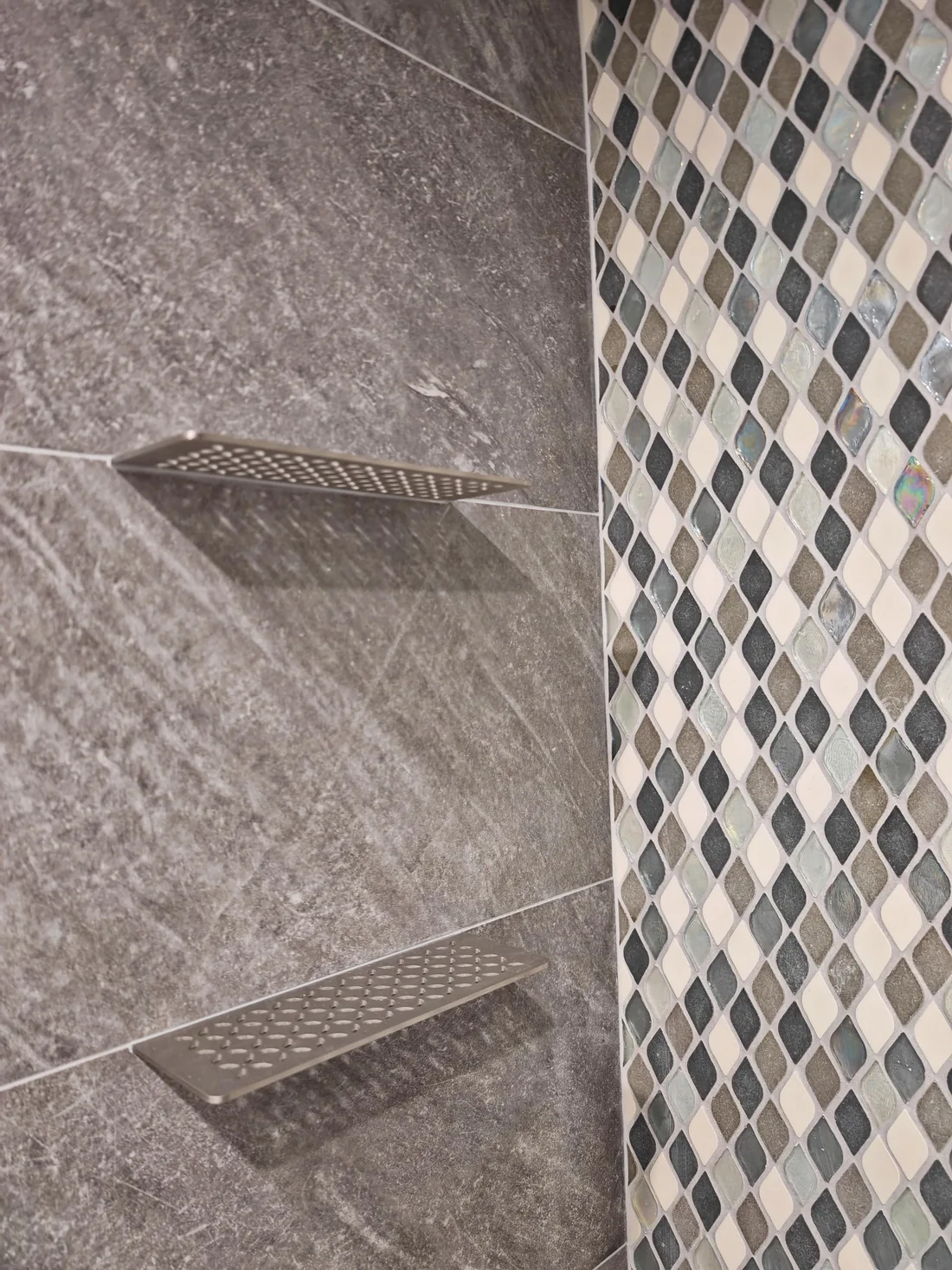 Modern shower with gray tile and mosaic accent