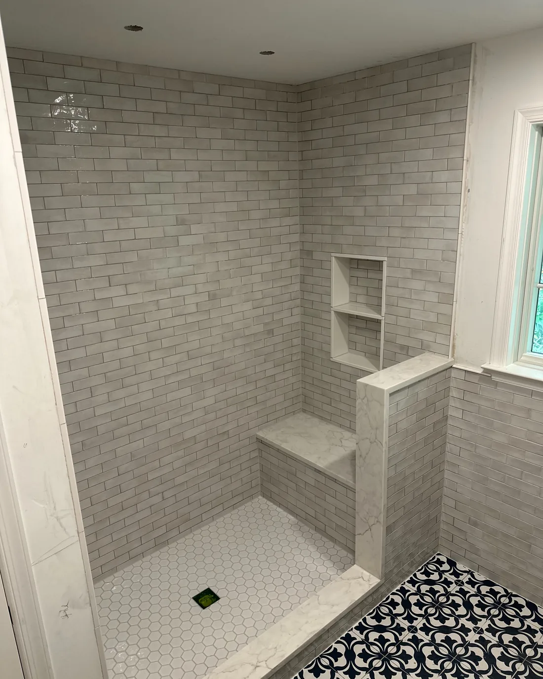 Modern bathroom shower with subway and hexagonal tiles