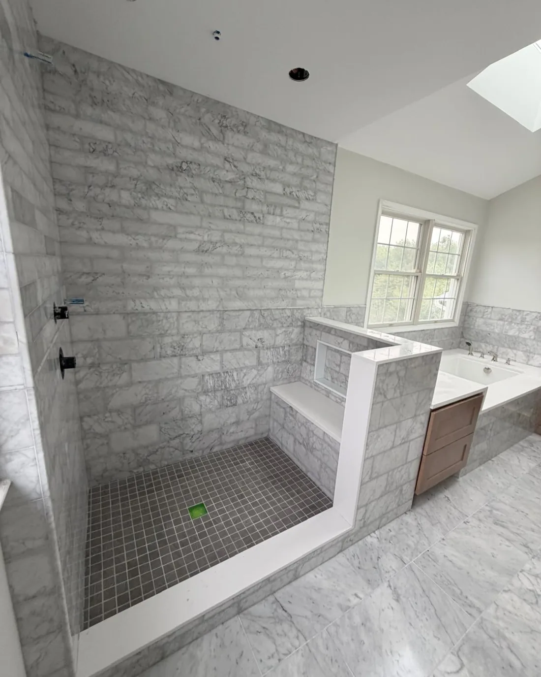 Luxurious marble tile bathroom with shower and tub.