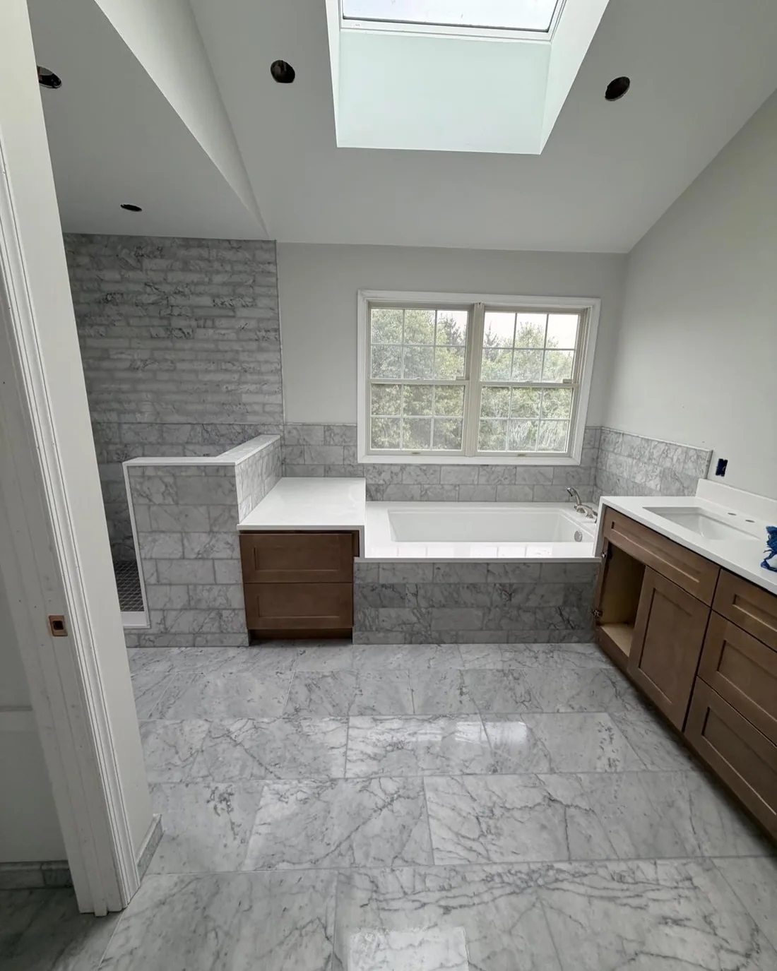 Luxurious marble tile bathroom with shower and tub.