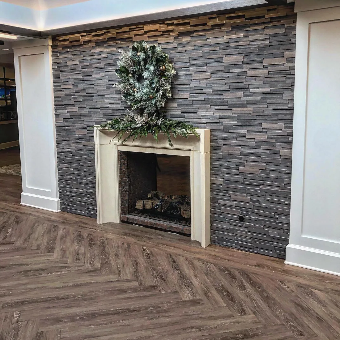 Stacked stone fireplace wall and wood floor