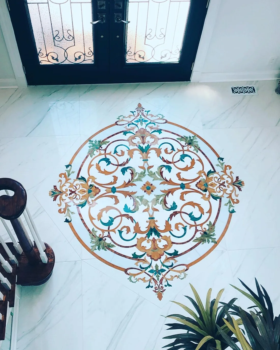 Ornate marble mosaic floor medallion in an elegant entryway.