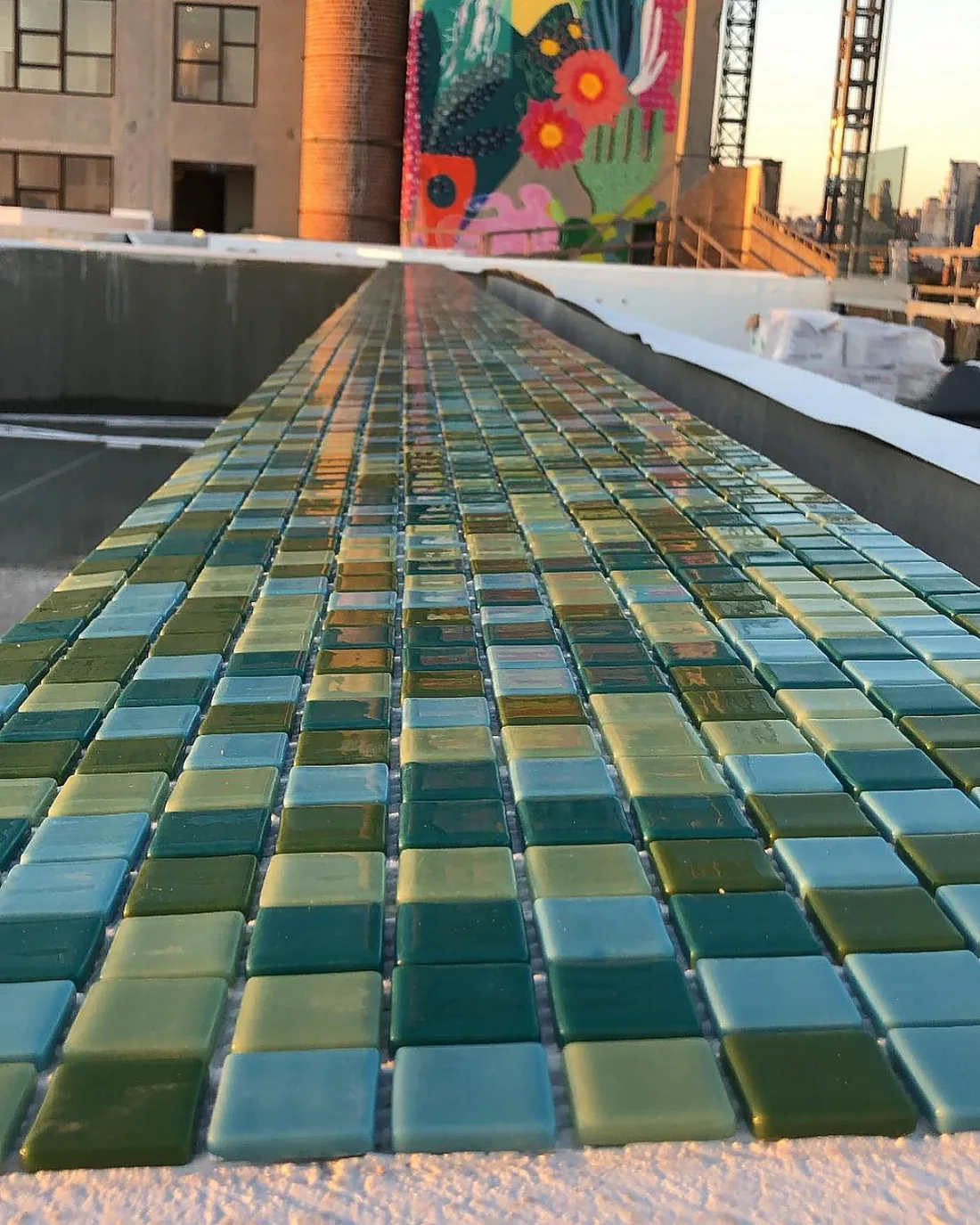 Green and blue mosaic tiles on a rooftop ledge.