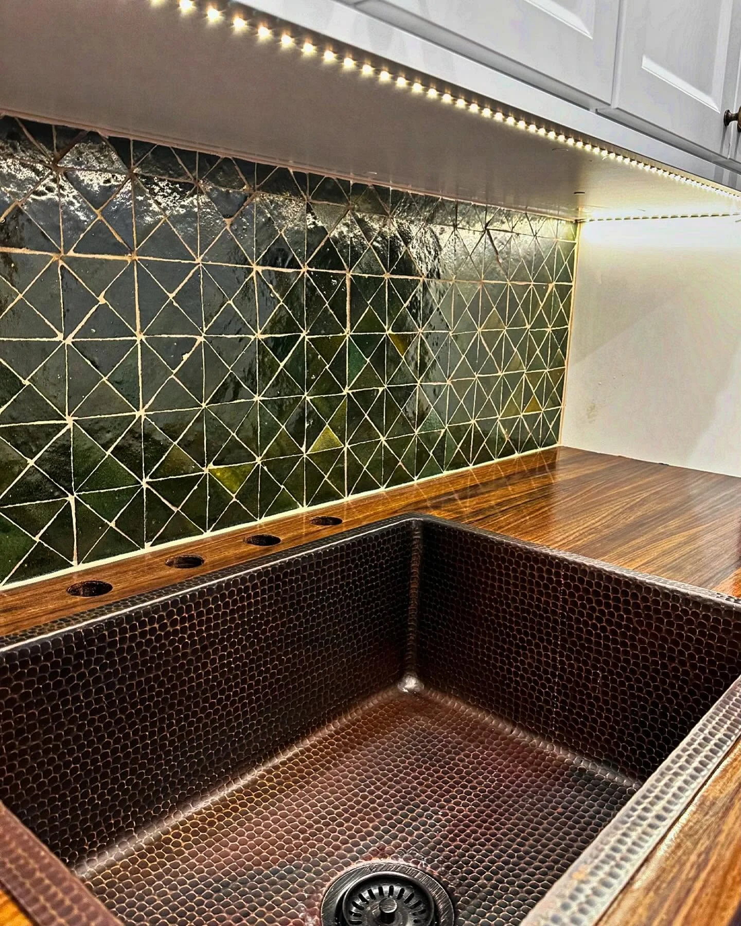 Dark green geometric tile backsplash with wood countertop and hammered copper sink. by Vicentino Ceramic Tile in Wayne, PA