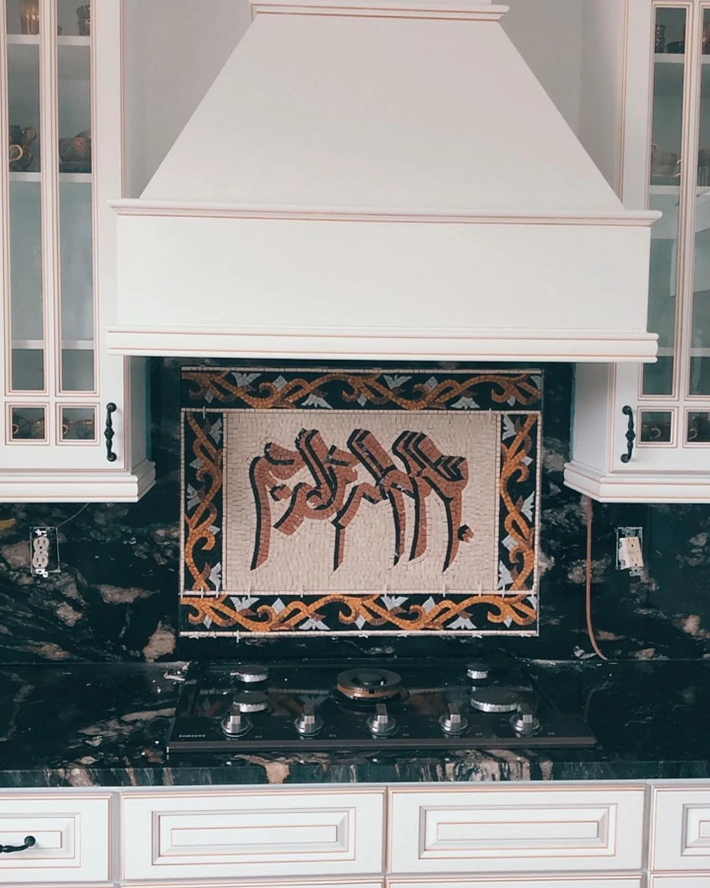 Kitchen backsplash with custom mosaic tile featuring arabic calligraphy and decorative border. by Vicentino Ceramic Tile in H