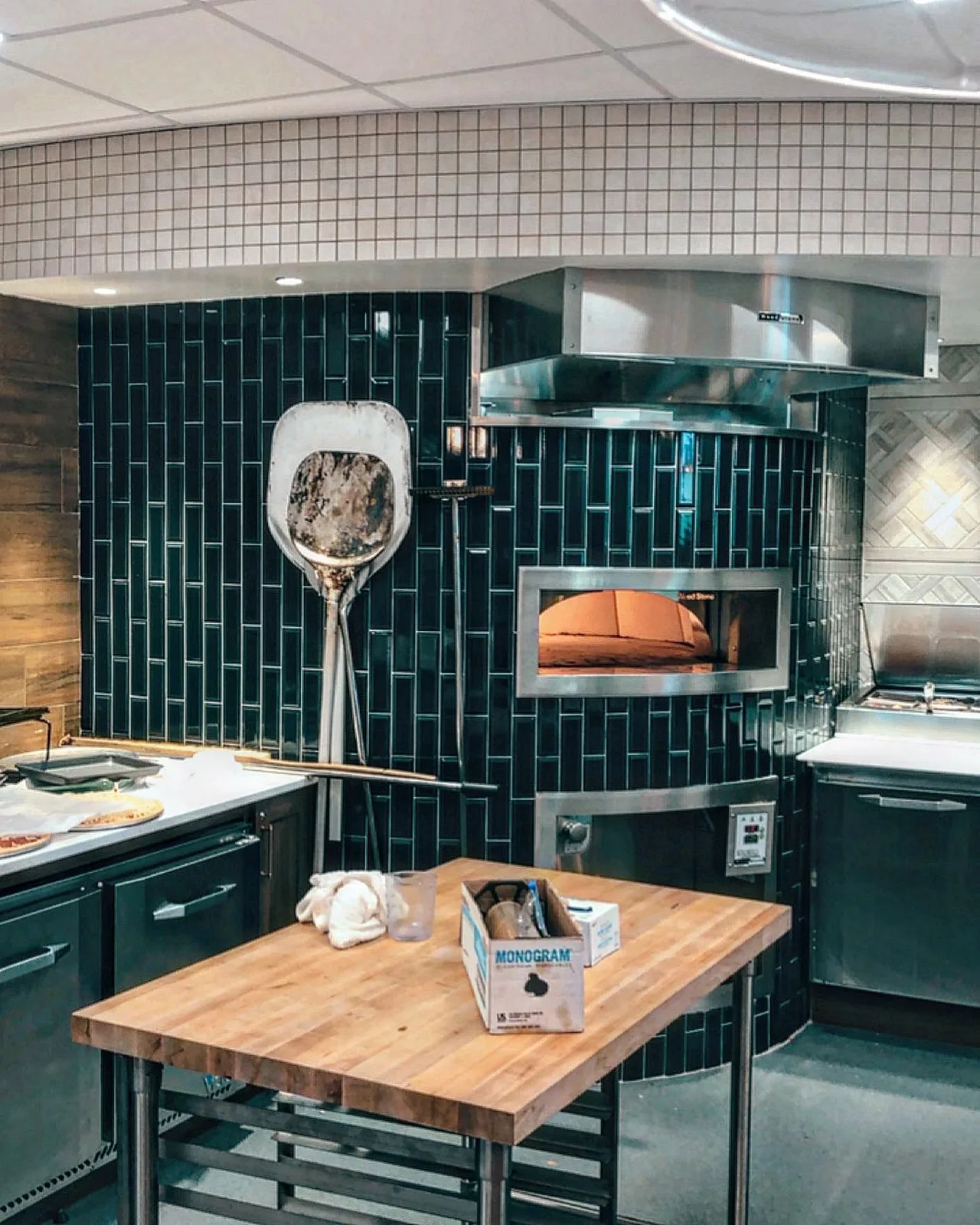 Commercial kitchen with dark subway tile backsplash