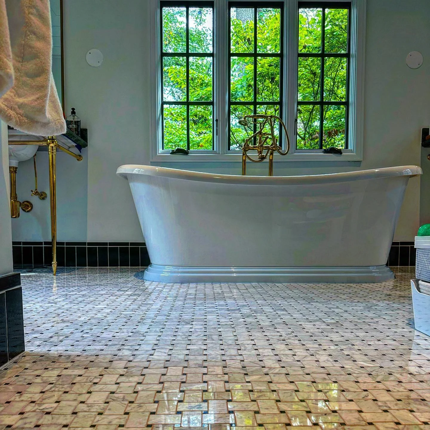 Elegant bathroom with white marble mosaic floor tiles and black subway tile wainscoting. by Vicentino Ceramic Tile in Ya