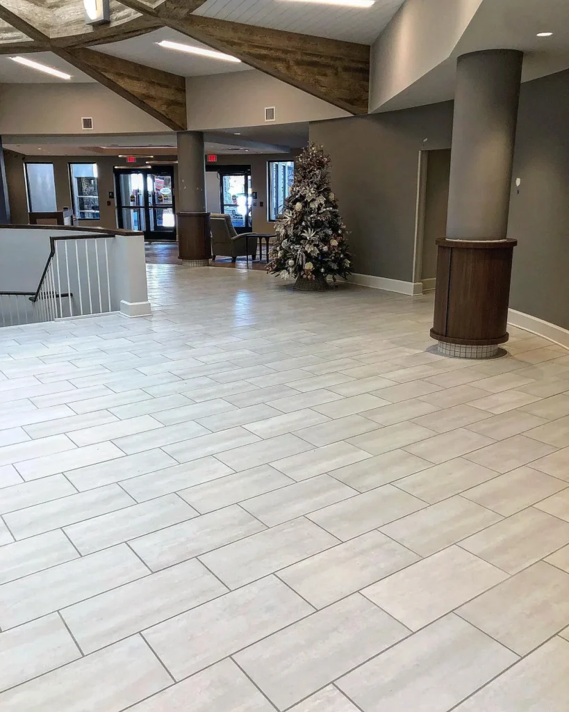 Light grey rectangular tile flooring in a large, modern commercial lobby area. by Vicentino Ceramic Tile in Newtown, PA