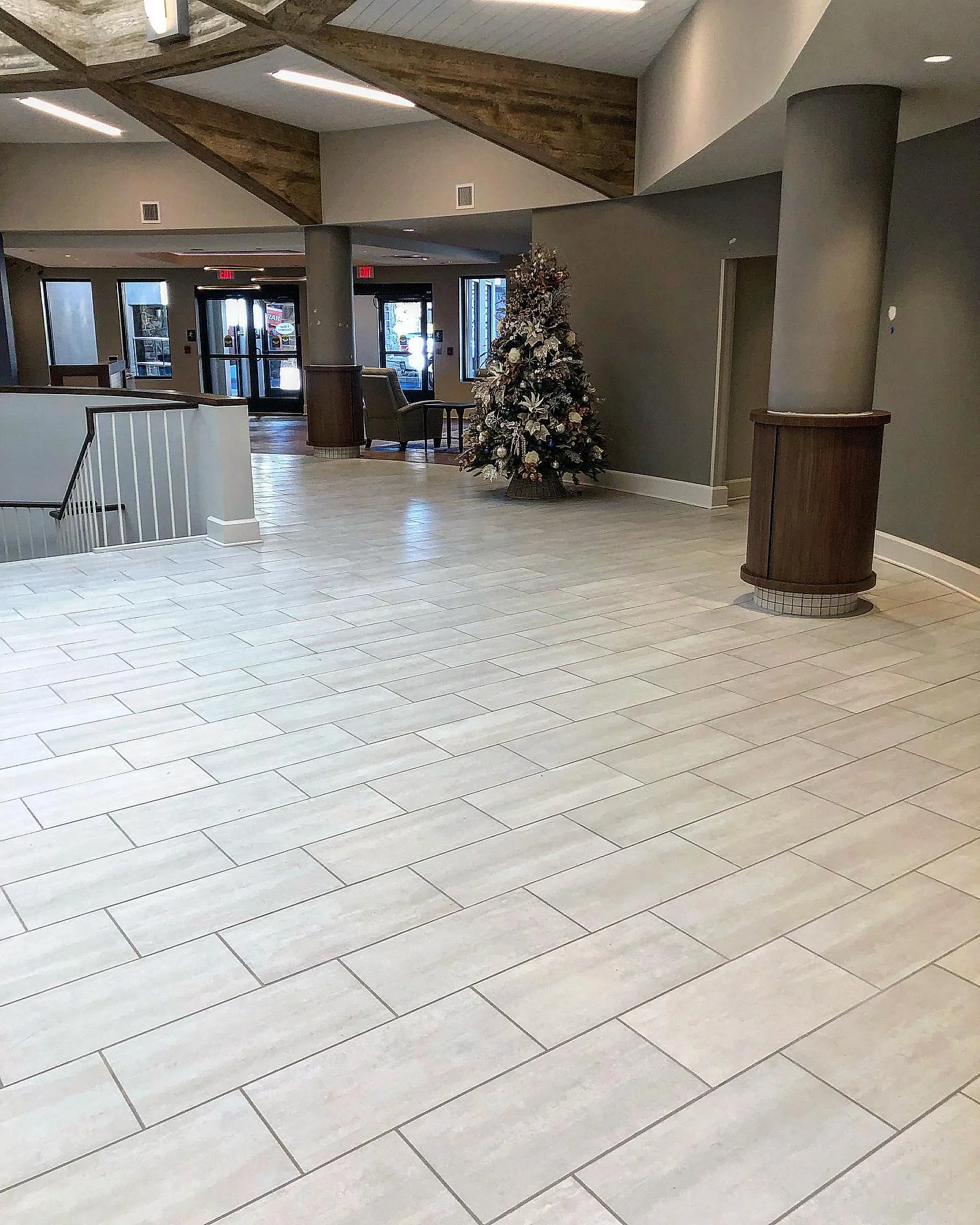 Light grey rectangular tile flooring in a large, modern commercial lobby area. by Vicentino Ceramic Tile in Newtown, PA
