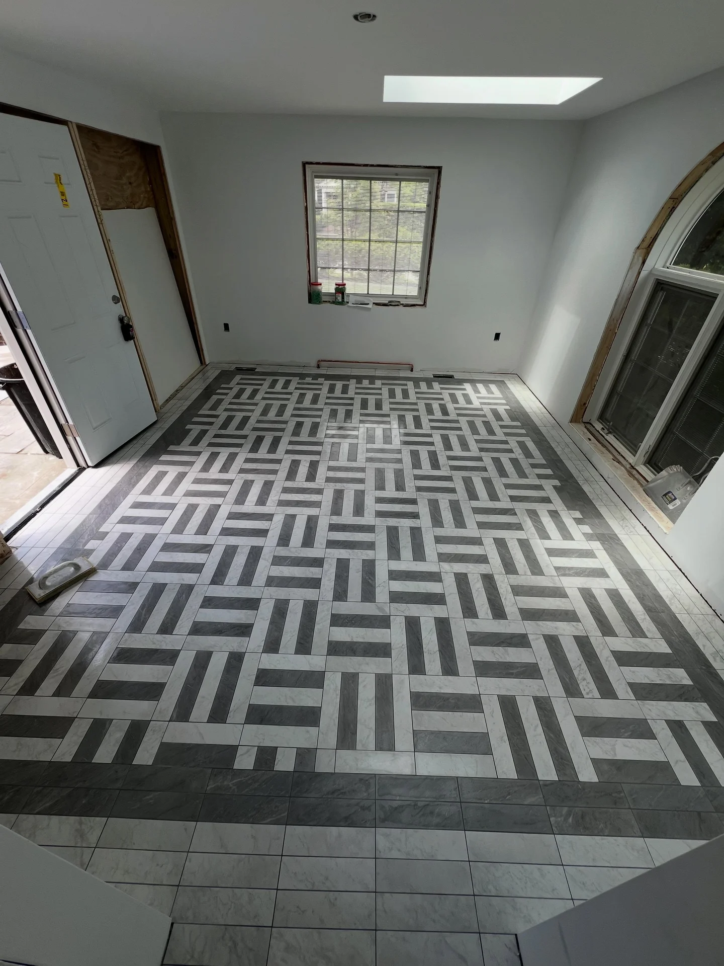 Newly installed gray and white patterned tile flooring in a bright room. by Vicentino Ceramic Tile in Wayne, PA