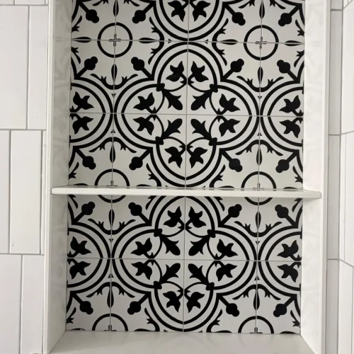 Black and white patterned tile niche with white subway tile surround and shelf. by Vicentino Ceramic Tile in Blue Bell, PA