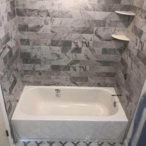 New bathtub and shower walls with gray and white marble subway tile. by Vicentino Ceramic Tile in Bryn Mawr, PA