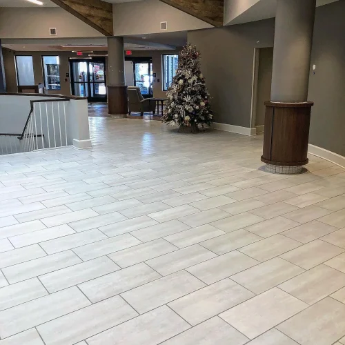 Light grey rectangular tile flooring in a large, modern commercial lobby area. by Vicentino Ceramic Tile in Newtown, PA